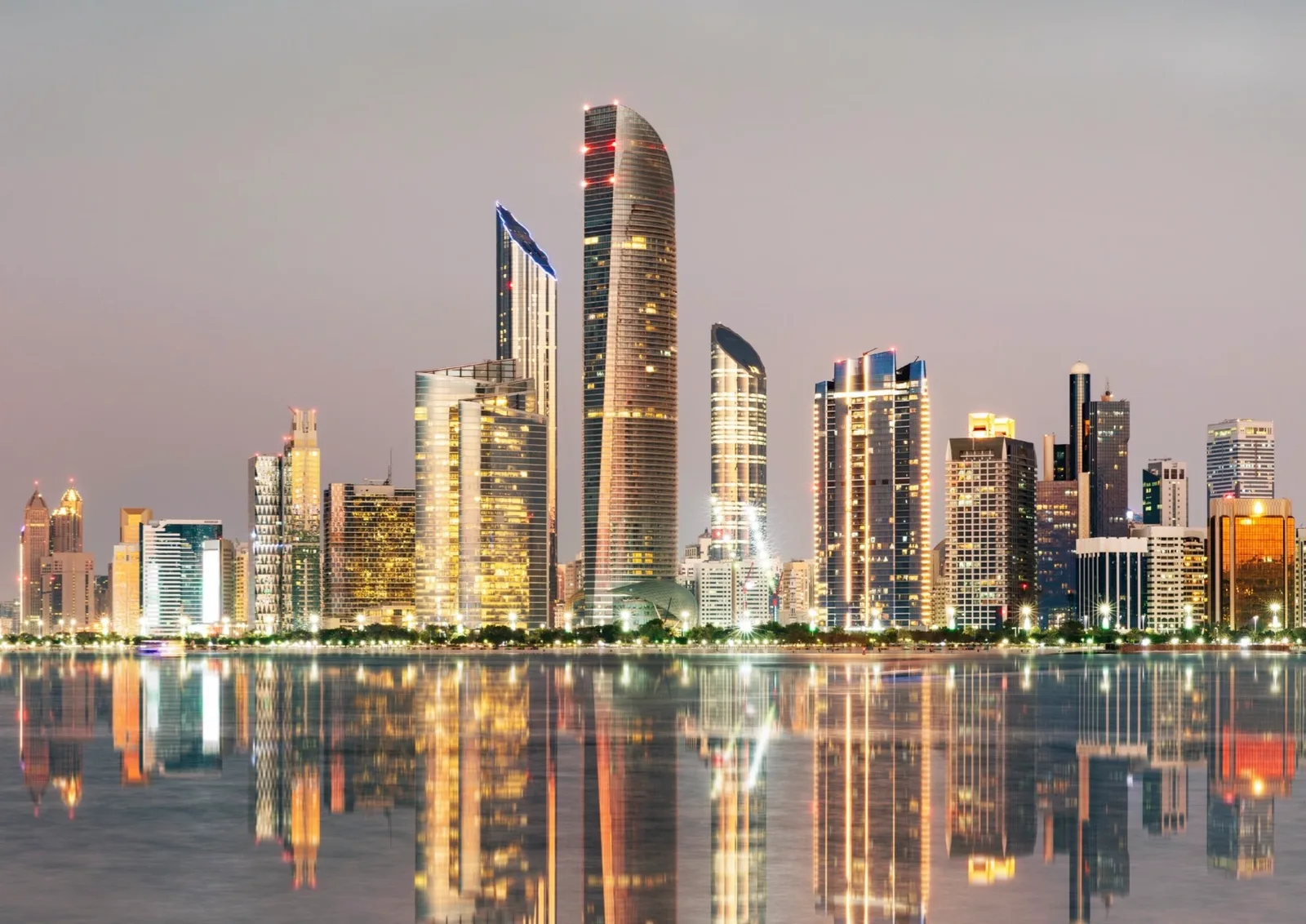 The Abu Dhabi skyline at dusk mirrored in the water of the Corniche